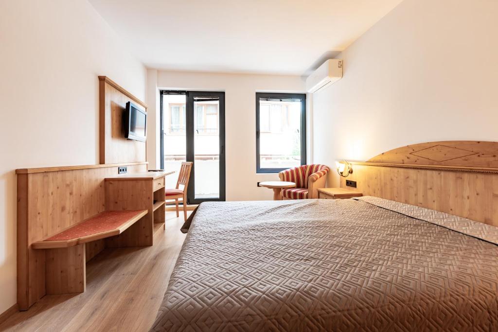 a hotel room with a bed and a desk and a chair at Vitosha Park Apart in Sofia