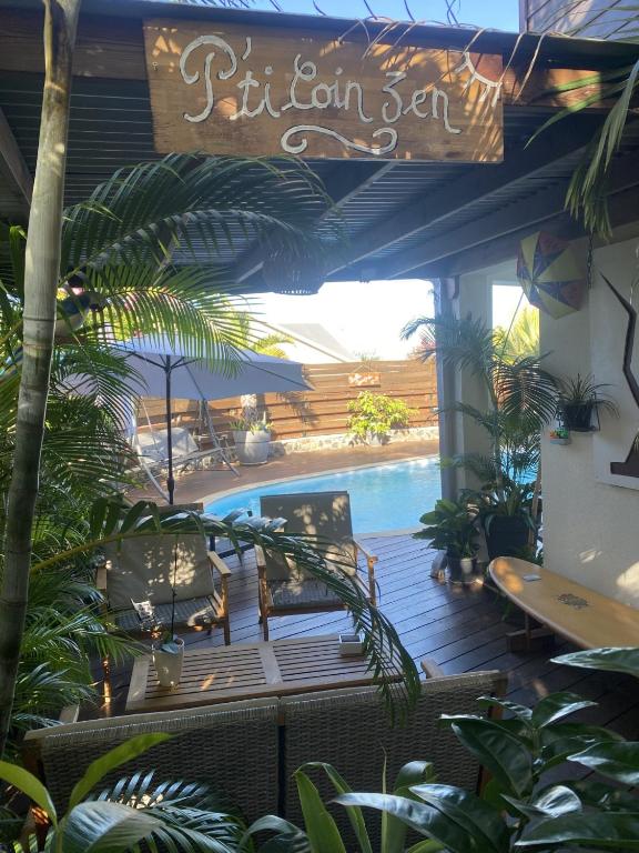 a patio with a pool and a sign that reads sitourn son at P'ti coin zen in Saint-Gilles-les-Bains