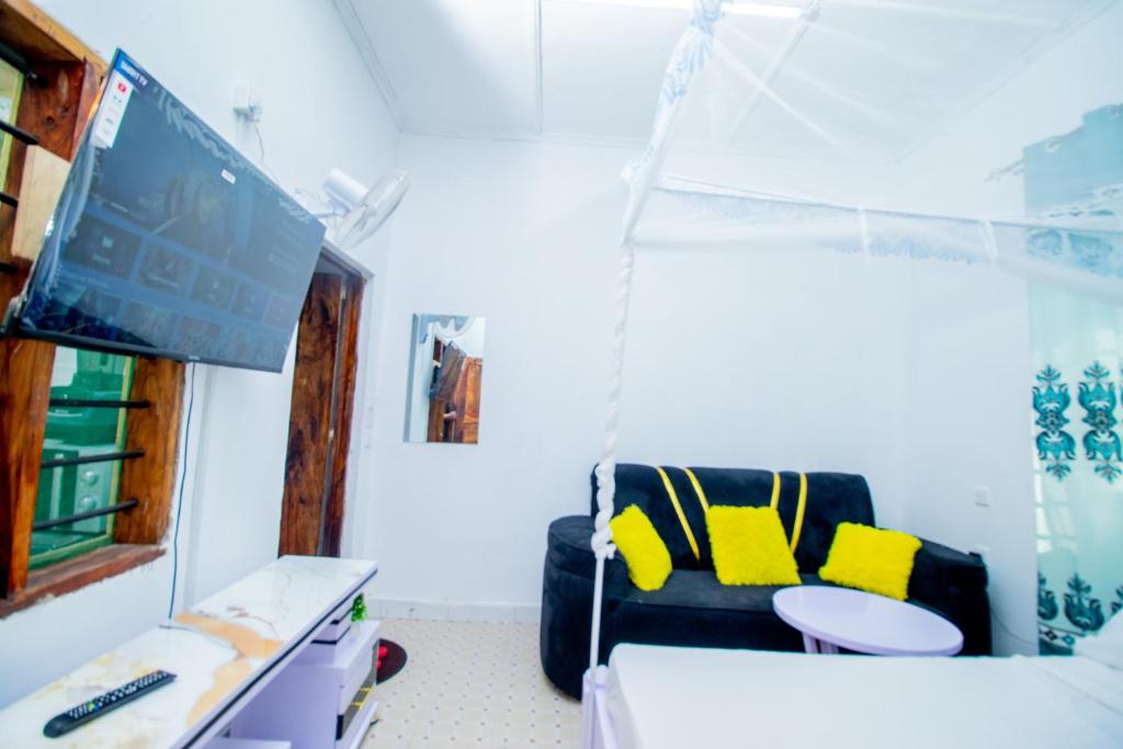 a living room with a couch and a tv in a room at Avana Studio Watamu in Watamu