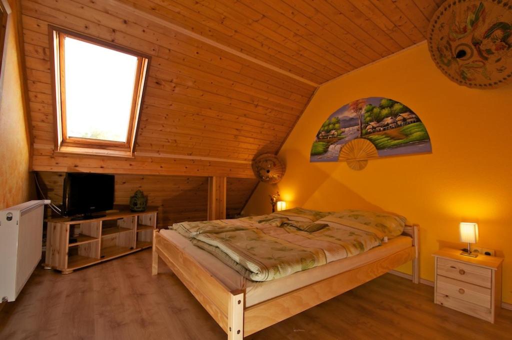 a bedroom with a bed and a tv in a room at Bringatanya in Balatonkenese