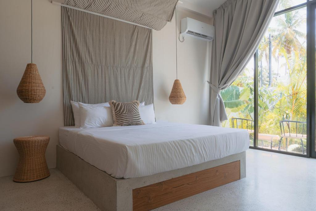 a bedroom with a bed with a large window at Air Villa in Ahangama