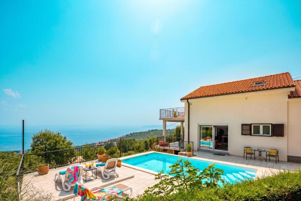 a villa with a swimming pool and a house at Hillside Villa Kvarner: Pool & Sea View - Happy Rentals in Ičići