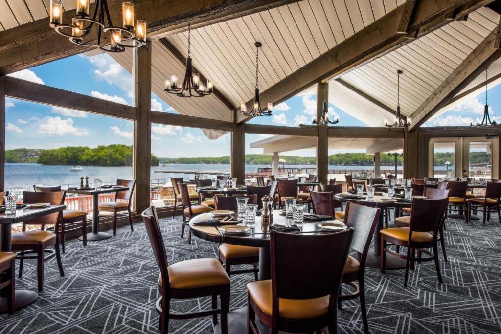 a restaurant with tables and chairs and a view of the water at Tan-Tar-A Estates in Damsel