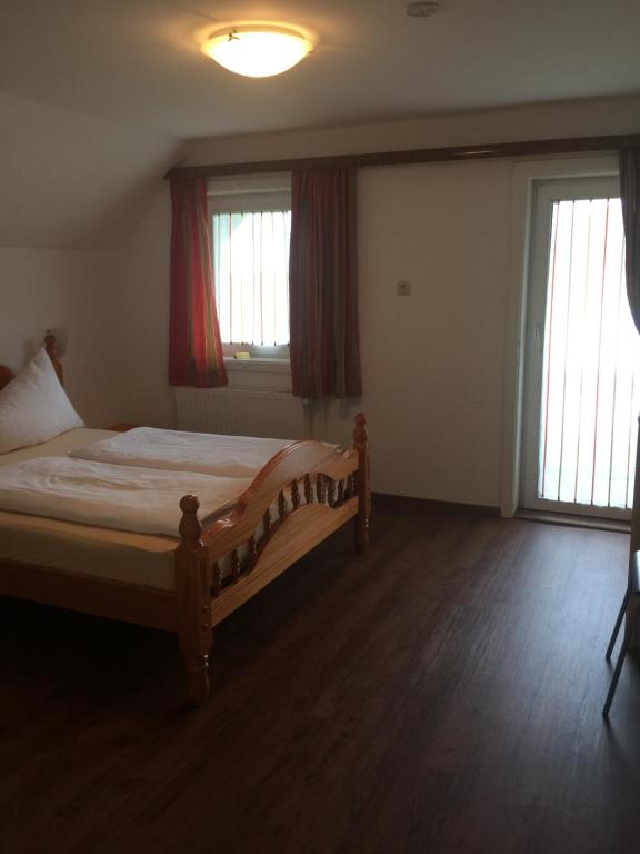 a bedroom with a bed and two windows at Ferienhaus Strasswirt in Jenig