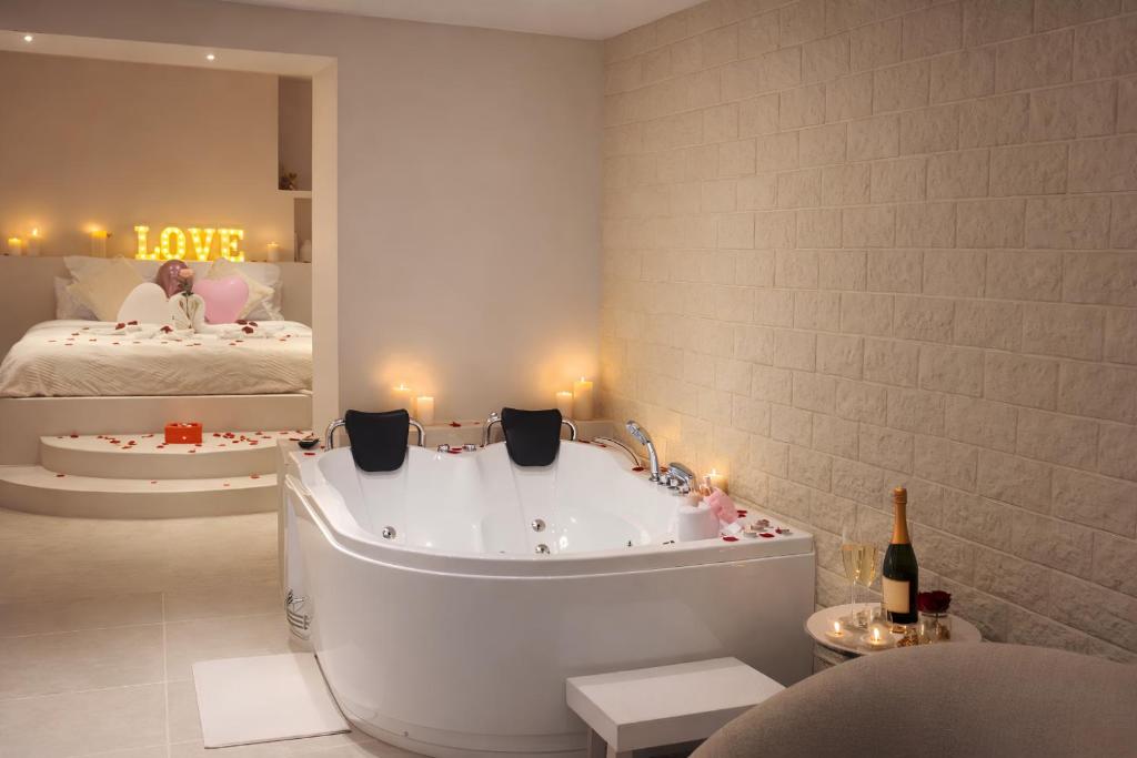 a bathroom with a bath tub and a bed at Suite Pacifique - Spa privatif avec baignoire in Calais