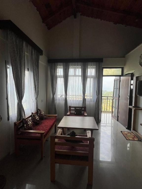 a living room with a table and a couch at The Himalayan Munros in Chaubattia