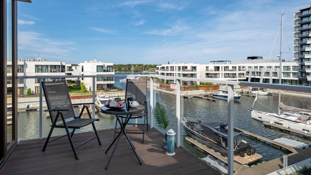 a balcony with chairs and a view of a marina at Solmarina, Sun&Snow in Wiślinka