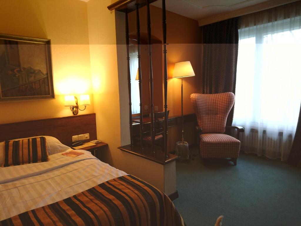 ラ・ショー・ド・フォンにあるホテル アトモスのベッドと椅子付きのホテルルーム