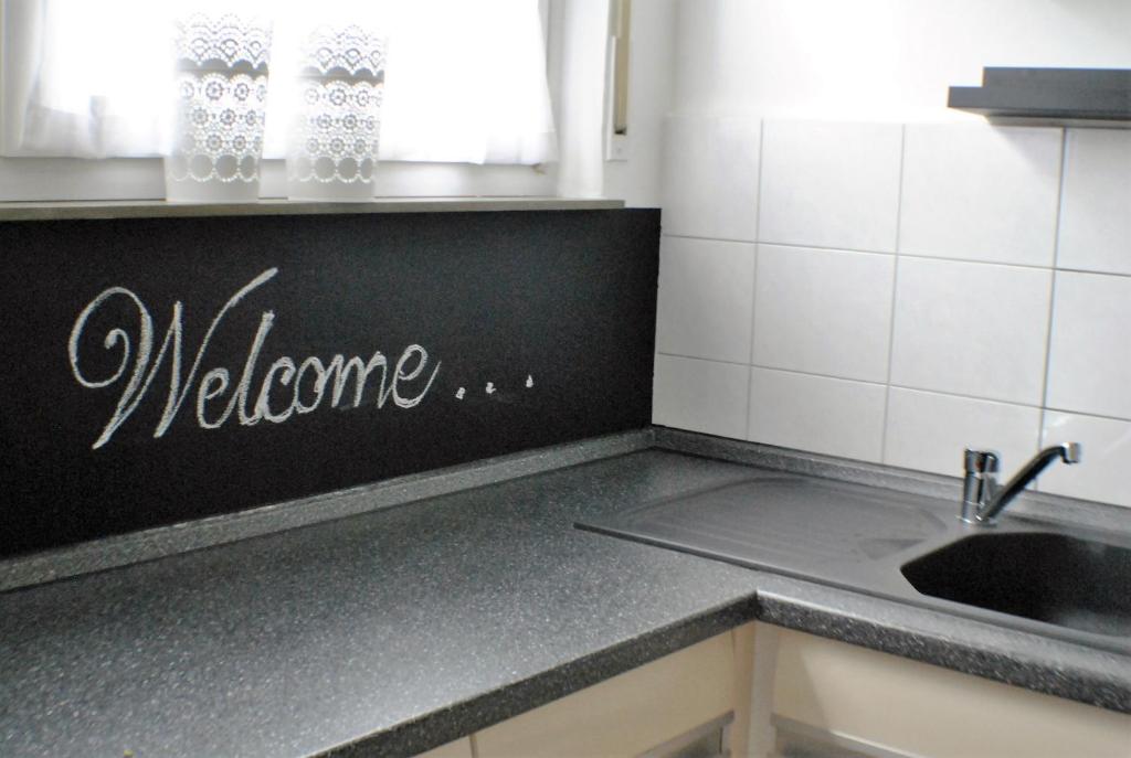 - une cuisine avec un panneau de bienvenue sur le comptoir dans l'établissement Ferienwohnung Marina Kassel, à Cassel