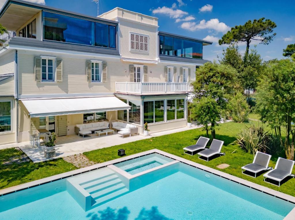 an exterior view of a house with a swimming pool at Villa Guidi 10 Emma Villas in Milano Marittima