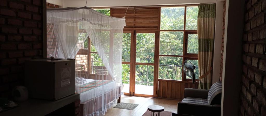 a room with a large window with a bed in it at Ayanura Ella in Ella