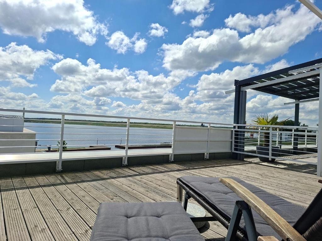 a deck with a bench and a view of the ocean at Ferienwohnung Strandblick in Großräschen