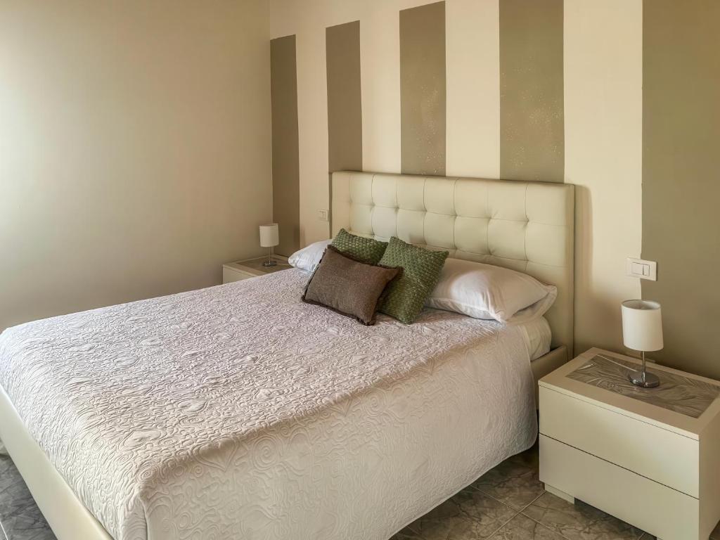 a bedroom with a large white bed with two tables at Casa Vacanze Francesca in Mondolfo