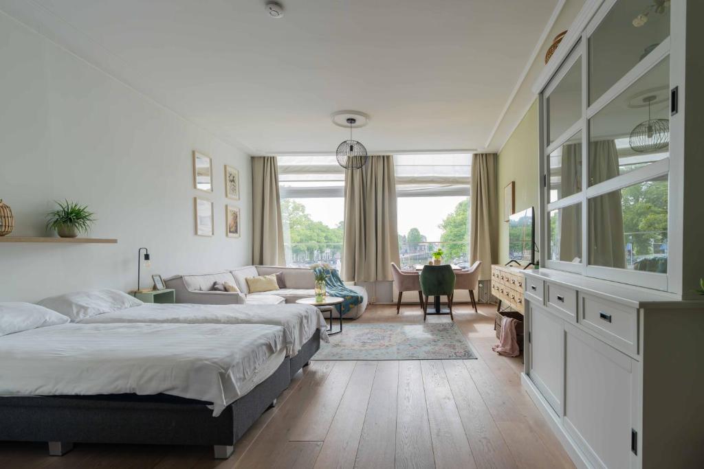 a bedroom with two beds and a living room at Job Baster Kraanplein - Het Zonnehof in Zierikzee