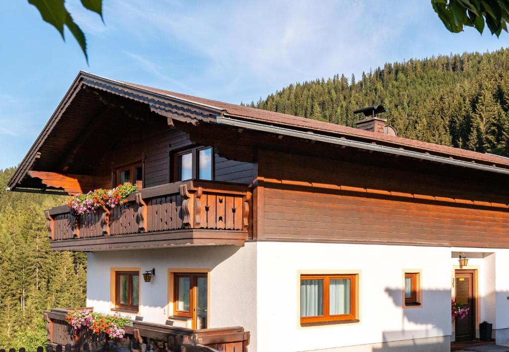 a house with a balcony and trees in the background at Ferienhaus Bucheggerhof in Schladming
