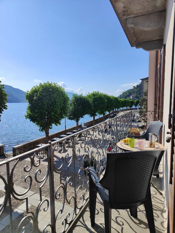 a balcony with a table and chairs and the water at Casa Farfalla in Cannobio