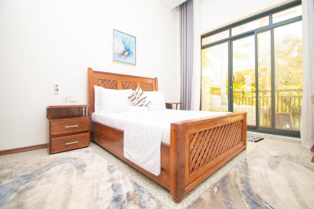 a bedroom with a large bed and a large window at Mnazi Dream House in Kiwengwa