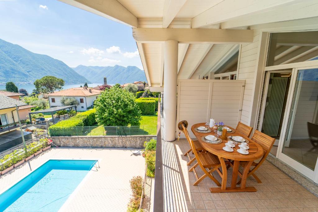 a patio with a table and chairs and a pool at The A-LINE Lake COMO view apt A with pool & garage in Tremezzo