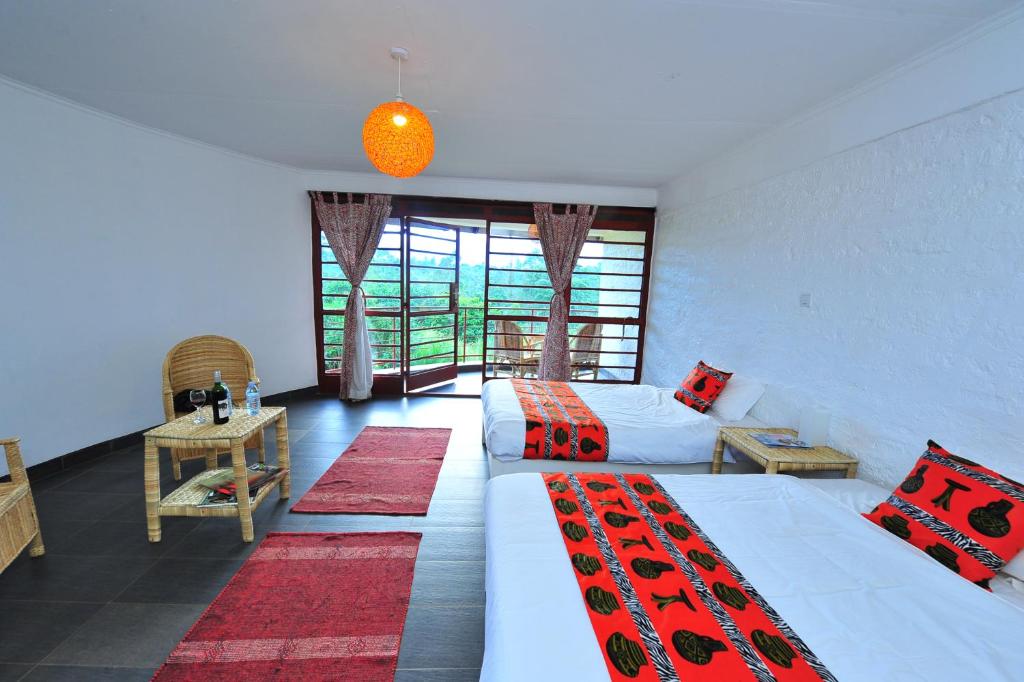 a hotel room with two beds and a window at Koi Koi, Fort Portal in Fort Portal
