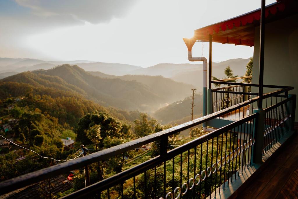 a balcony of a house with a view of mountains at Jigyasa Homestay in Almora
