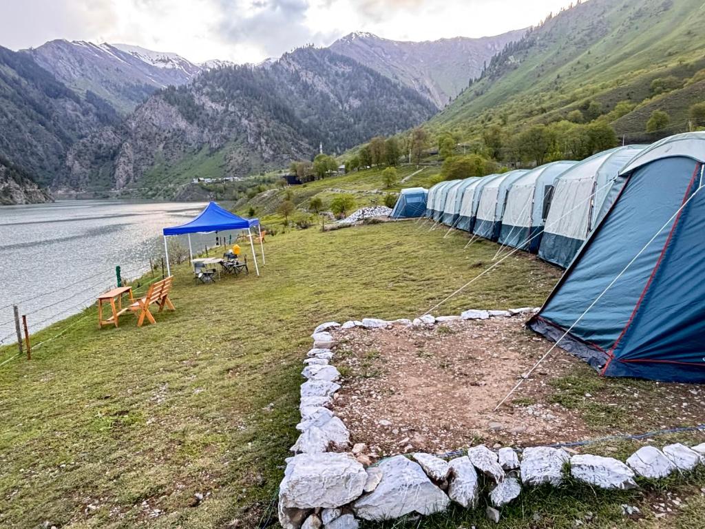 a row of tents on the side of a lake at Kishangangacampsgurez in Wāmpor