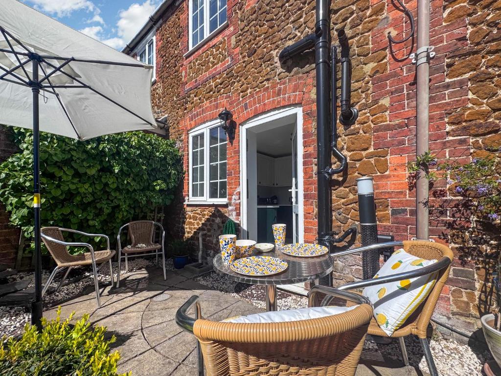 a patio with a table and chairs and an umbrella at Little Tern in Snettisham