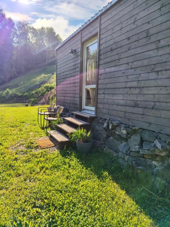 a house with a bench next to a window at Tinyhouse Cecilka in Ústí nad Orlicí