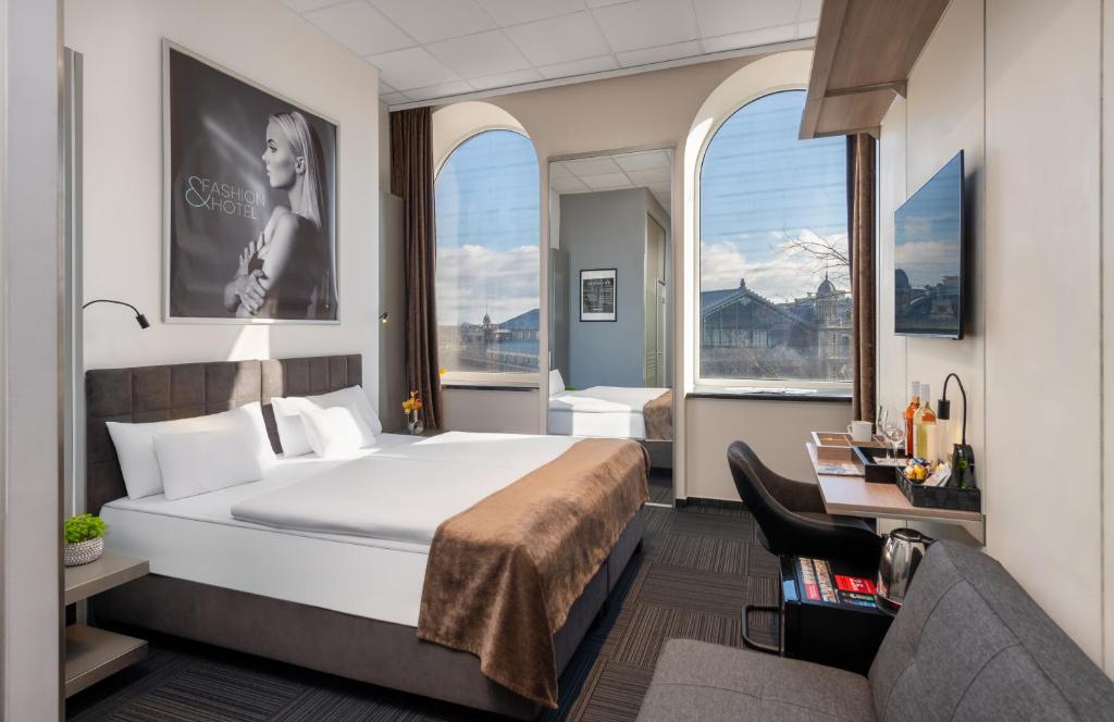 a hotel room with a bed and a couch at Fashion City Hotel Superior in Budapest