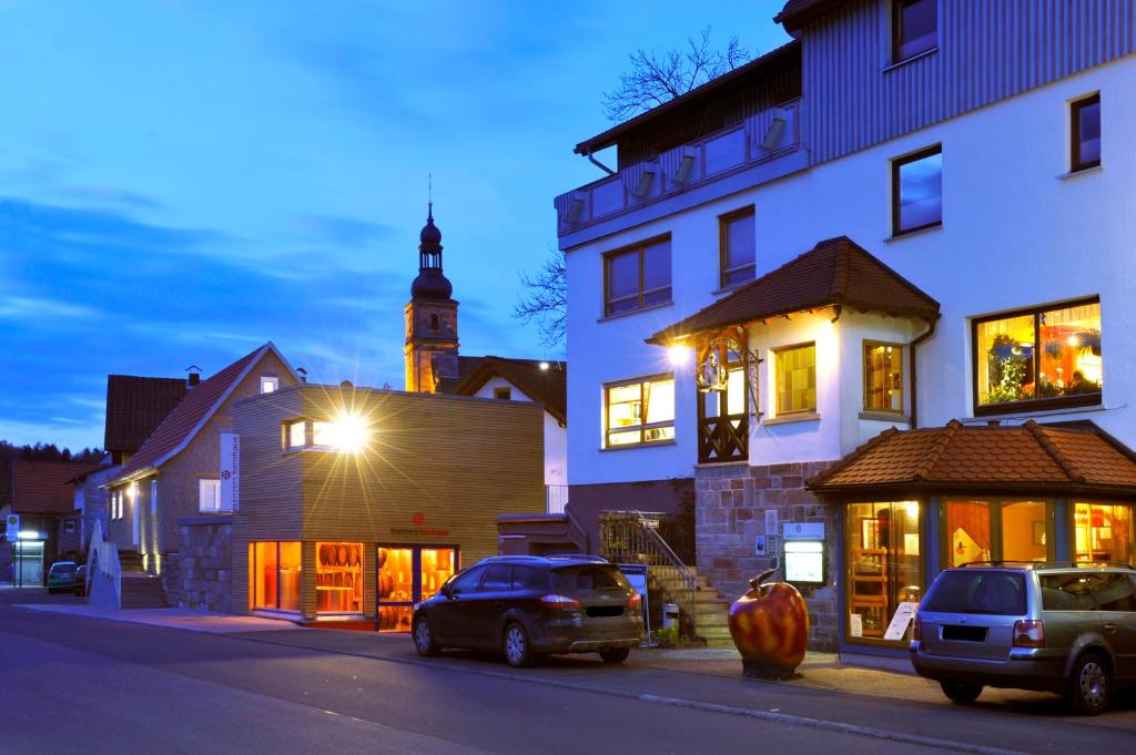 a city street with cars parked in front of a building at krenzers rhön in Melperts