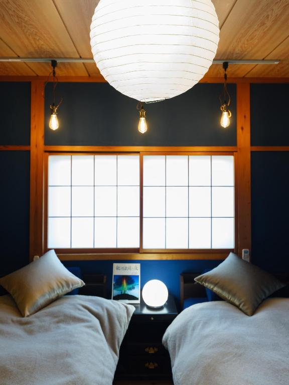 two beds in a room with a large window at 信の宿 花巻 in Hanamaki
