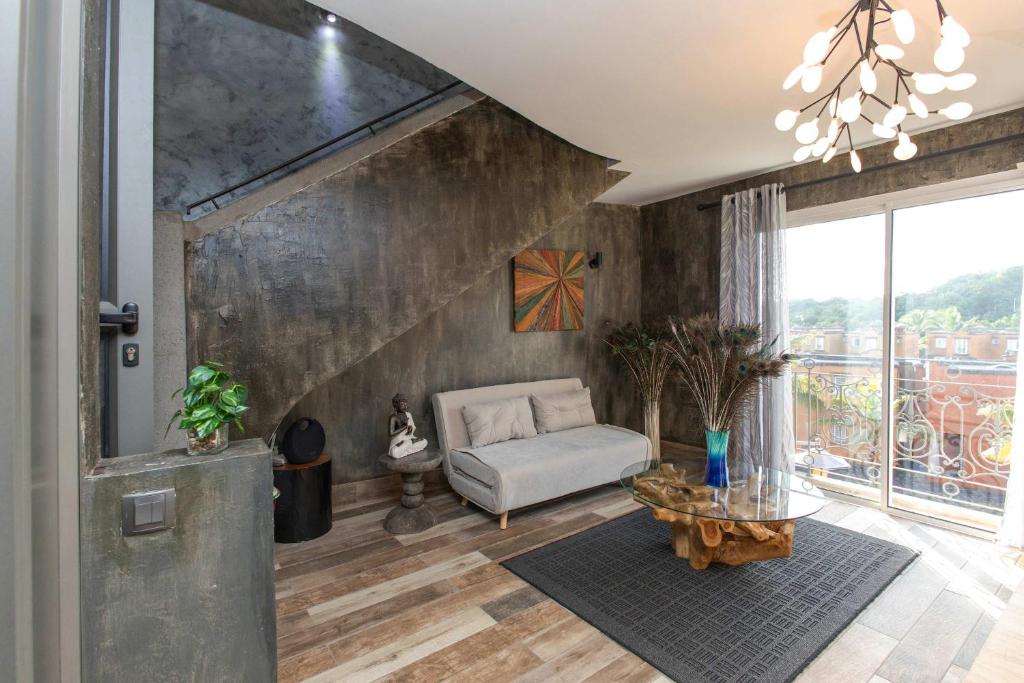 a living room with a couch and a table at Charming Duplex Mauritius' Little Venice in Terre Rouge