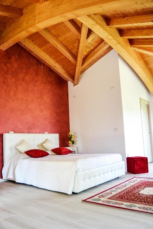 a bedroom with a white bed and a red wall at Rama Relais in Caprino Veronese