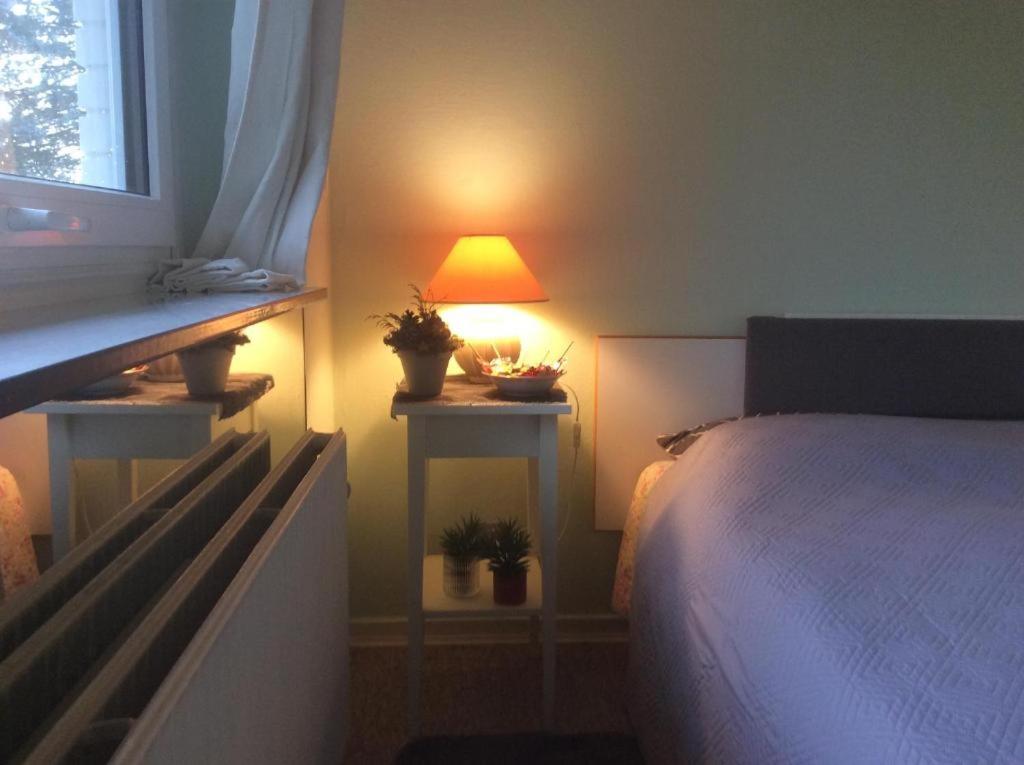 a bedroom with a bed with a lamp and a window at FLC 11 Rooms in Rødby