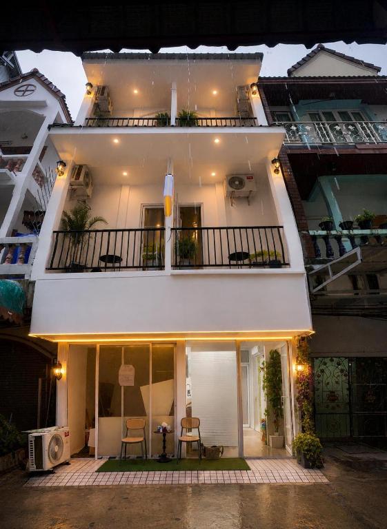 a large white building with a balcony with chairs at Patong Beach Verve in Patong Beach