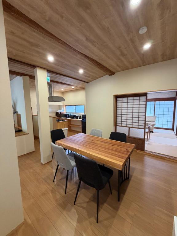 a dining room with a wooden table and chairs at 和風アンドラン in Minamiawaji