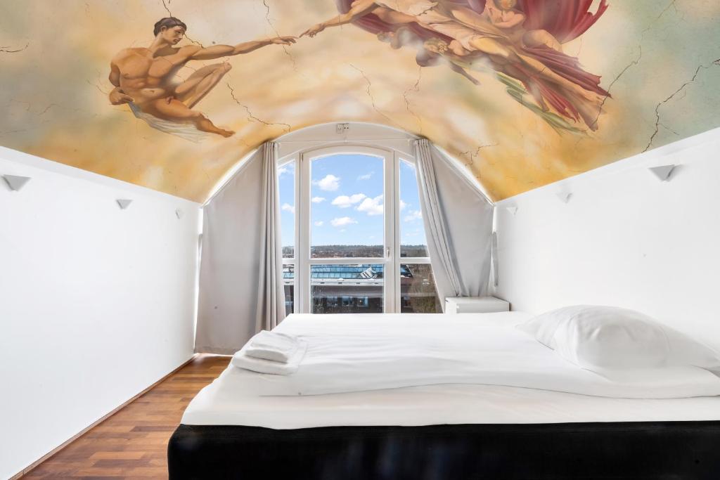 a bedroom with a bed with a painting on the ceiling at Holstebro Apartments in Holstebro