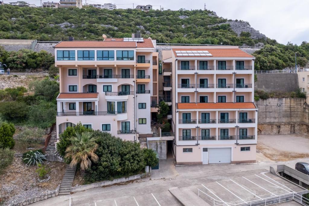 an apartment building in front of a mountain at Hotel Adria in Neum