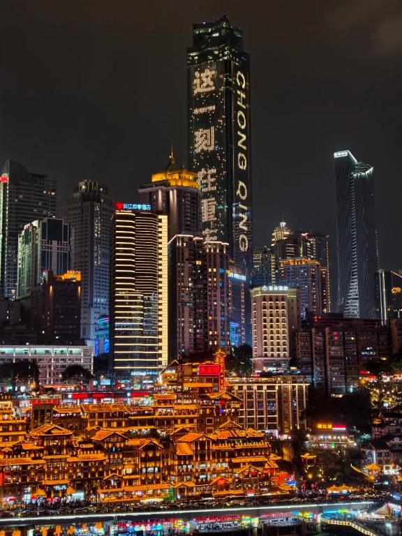 a lit up city skyline at night with buildings at 云涧江景酒店-重庆解放碑店 Chongqing Yunjian High-altitude River View Hotel-Jiefangbei Hongyadon in Chongqing