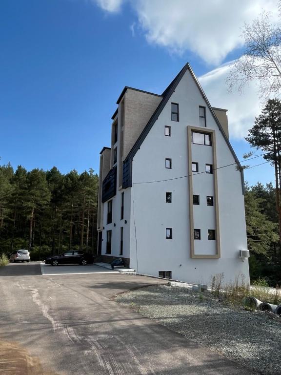 a white building on the side of a road at Apartmani Planinski Bor in Divčibare