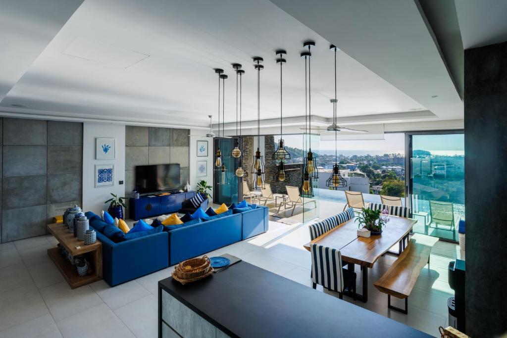 a living room with a blue couch and a table at Villa Momo seaview pool & game room Kata in Kata Beach