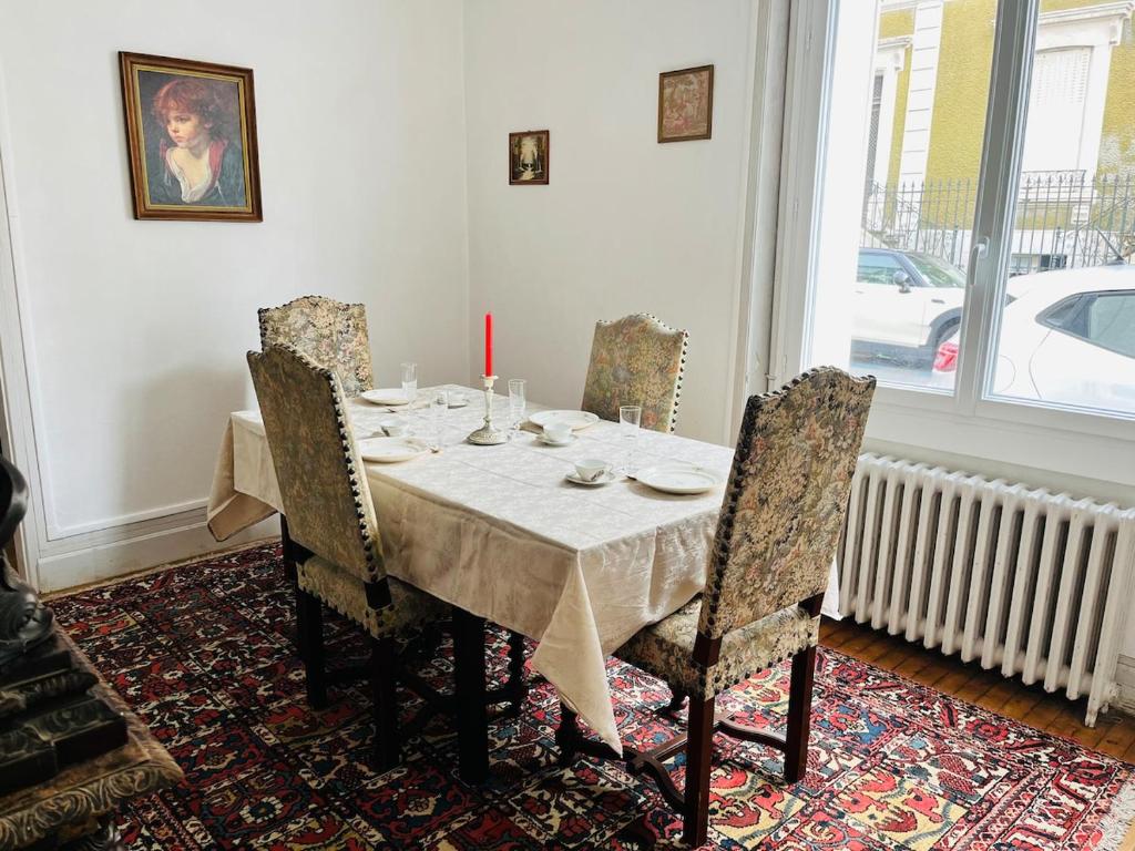 a dining room table with chairs and a candle on it at Le boudoir de Marie in Montluçon