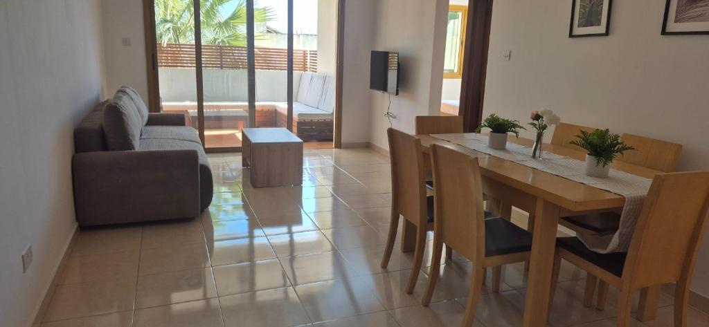 a living room with a dining room table and chairs at Nautical Nest in Livadhia