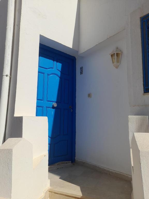 a blue door in a white room with stairs at Taguermess Tag 4 in Taguermess