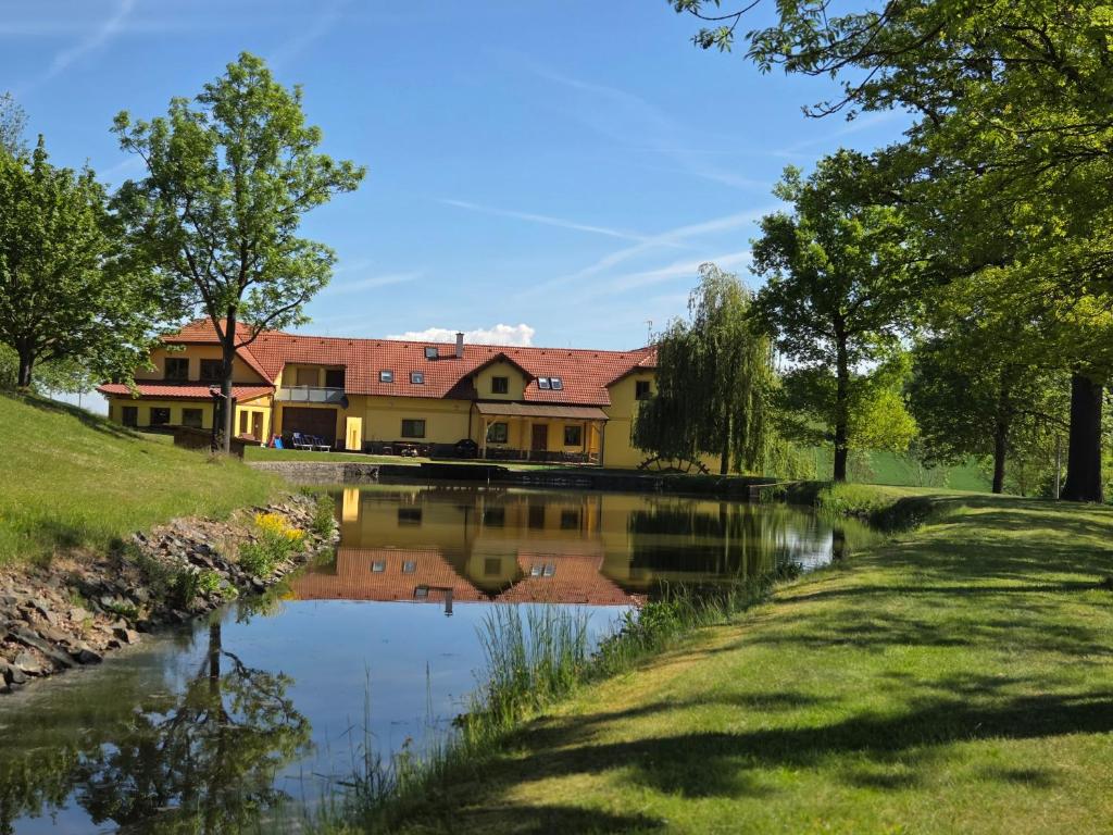 a house with a pond in front of it at Podveský mlýn in Tlumačov