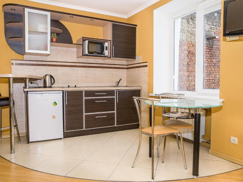 Il comprend une cuisine équipée d'une table, de chaises et d'un four micro-ondes. dans l'établissement Central Studio Tatiana, à Kharkov
