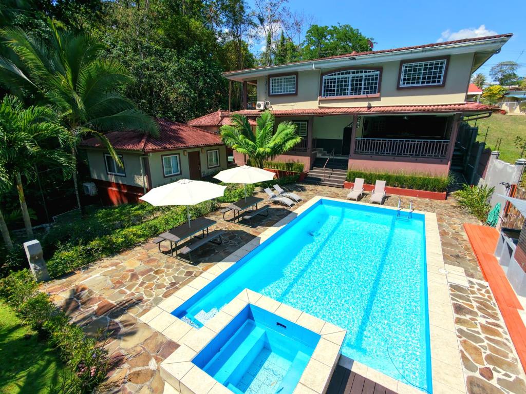 a swimming pool in front of a house at Coconut Lodge in Panama City