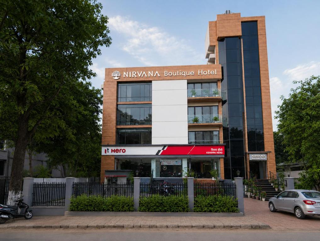 a building with a car parked in front of it at Nirvana boutique Hotel in Ujjain