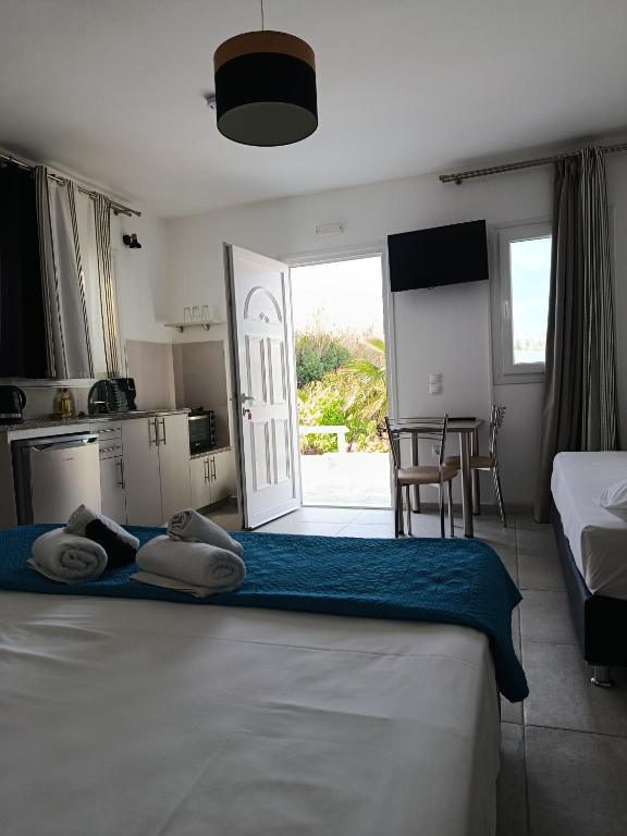 a bedroom with two beds and a kitchen and a table at NIKOLAS HOUSE CLOSE To TOWN in Mikonos