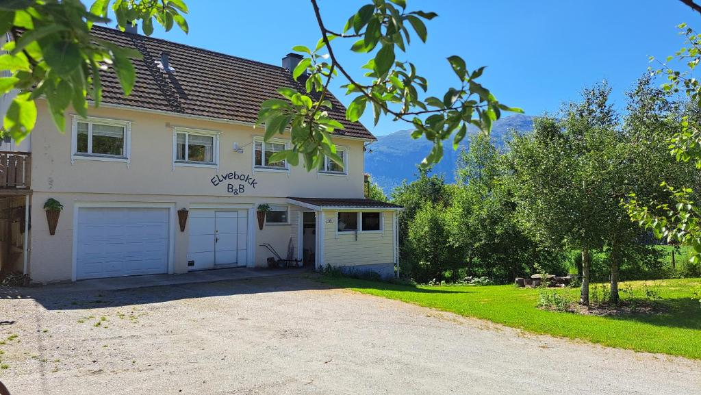 a large house with a garage and a driveway at Elvebakk Bed & Breakfast in Reed