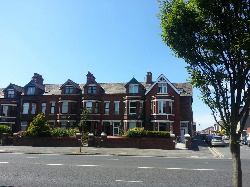 a large red brick building on a city street at Maindee Guest House in Barrow in Furness